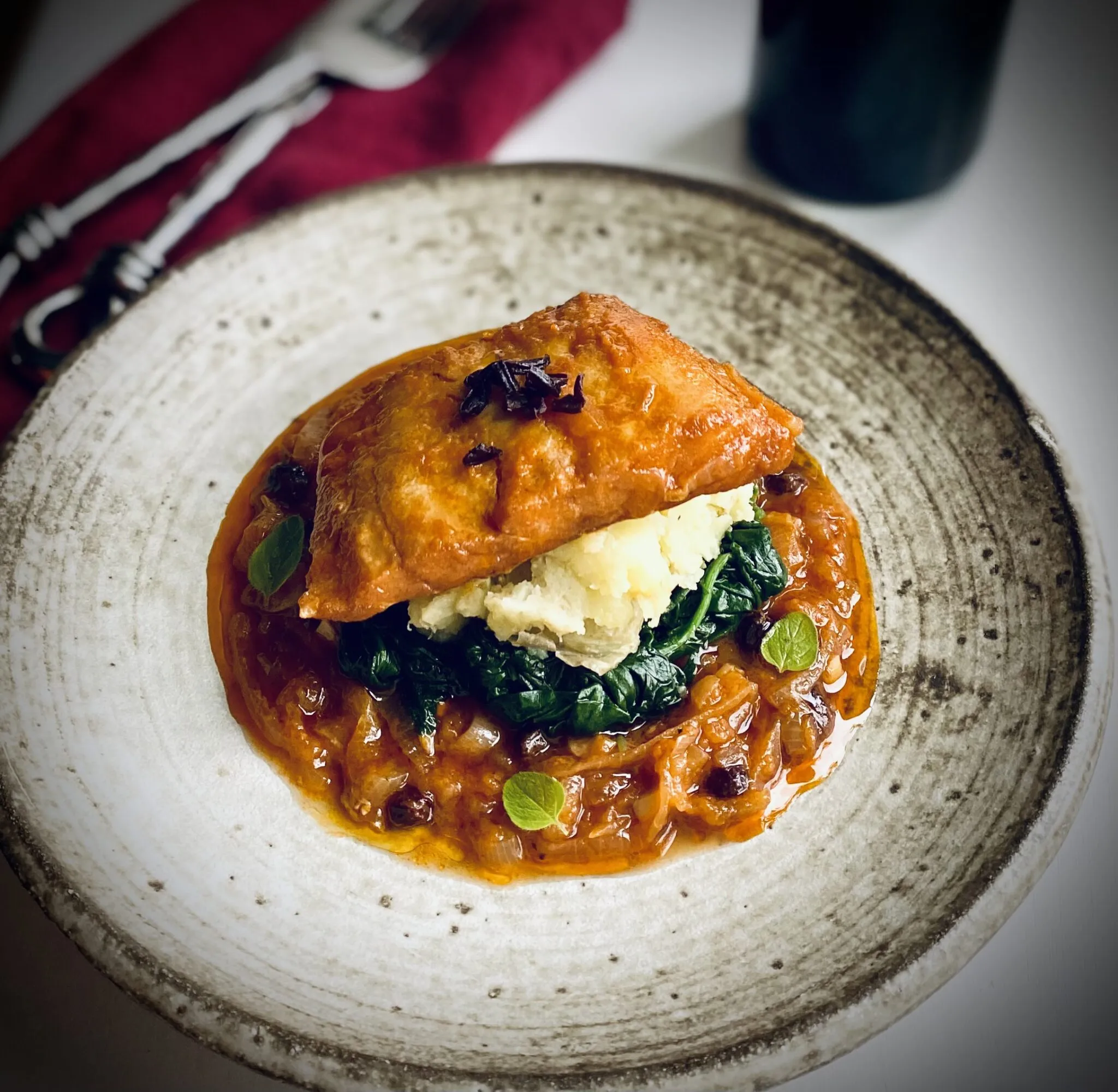 Traditional Greek Roasted Salted Cod with Onions, Tomatoes, and Raisins (Bakaliaro Plaki)